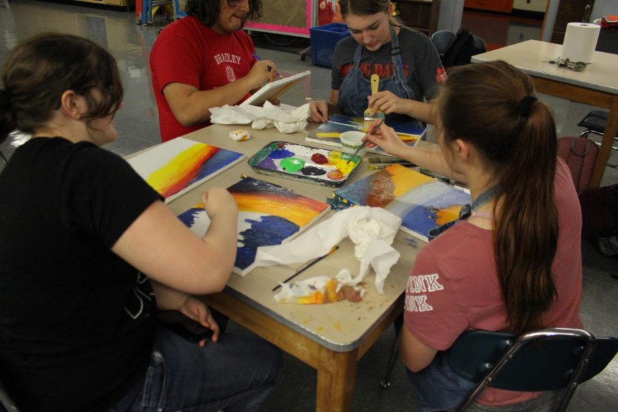 Jaci South, Wes Carpenter, Alyssa Place and Alison Venus all work on paintings during the Art Club session on the Bob Ross technique.