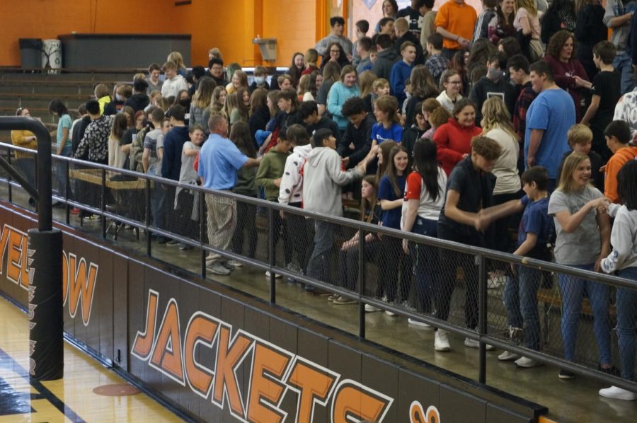 Students shake hands during one of the assembly activities.