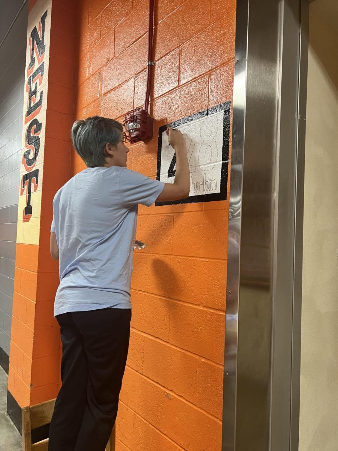 Kerringtyn Malley paints the room number for Mrs. Durbin.