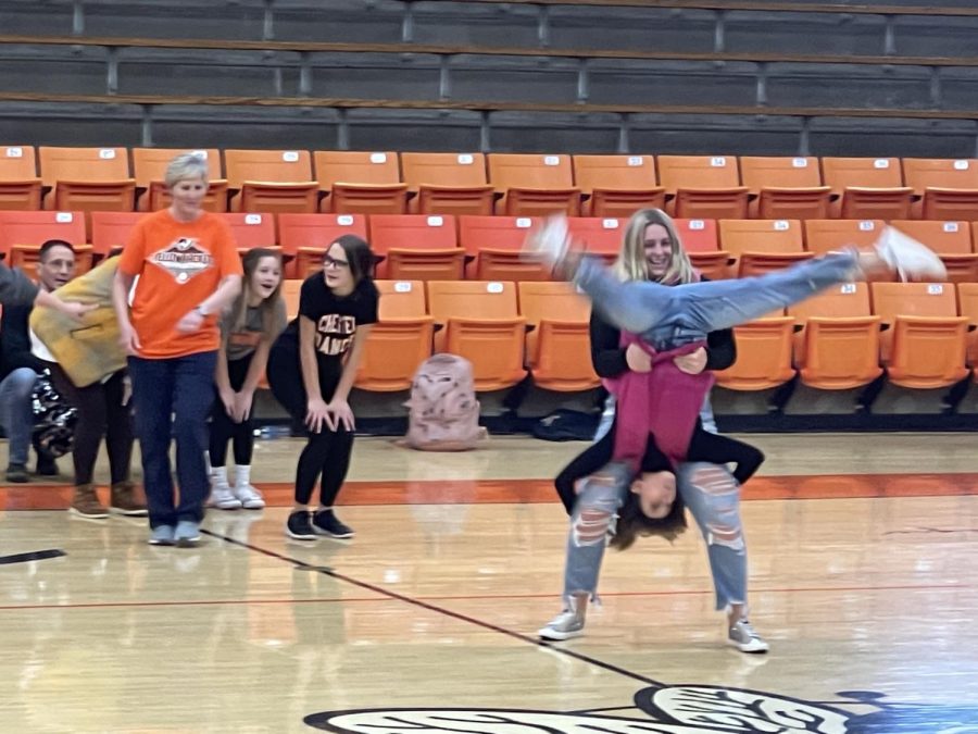 Emma Eggemeyer helps Mrs. Miller execute a somersault.