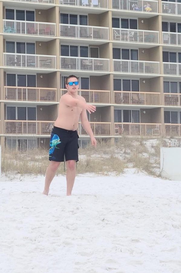 Dylan Hamilton tosses a football on a beach in Florida.