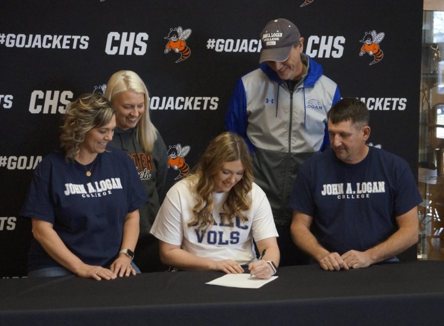 Surrounded by coaches and parents, Paige Vasquez signs a letter of intent to play volleyball at John A. Logan College.