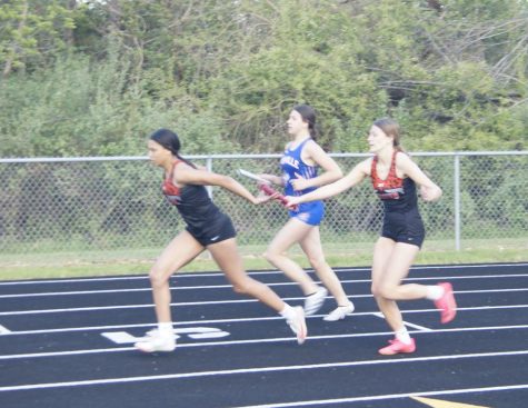 Jazzi Merideth and Gianna Eggemeyer make a handoff in the 4x200.