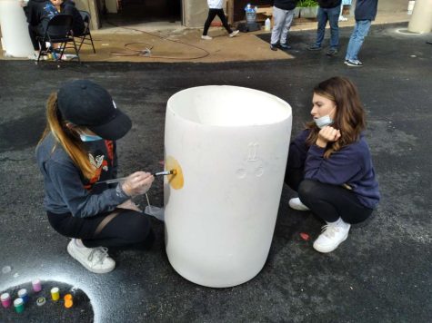 Students paint barrels for Earth Day.
