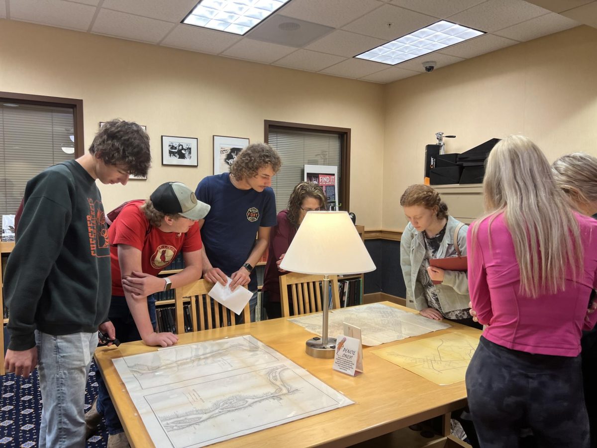 Bryce Cushman, Mason Werner, Maison Shemonic, Angie Werner, Bailey Sellers, Camryn Luthy, and Katelin Conway look at historical Chester records 